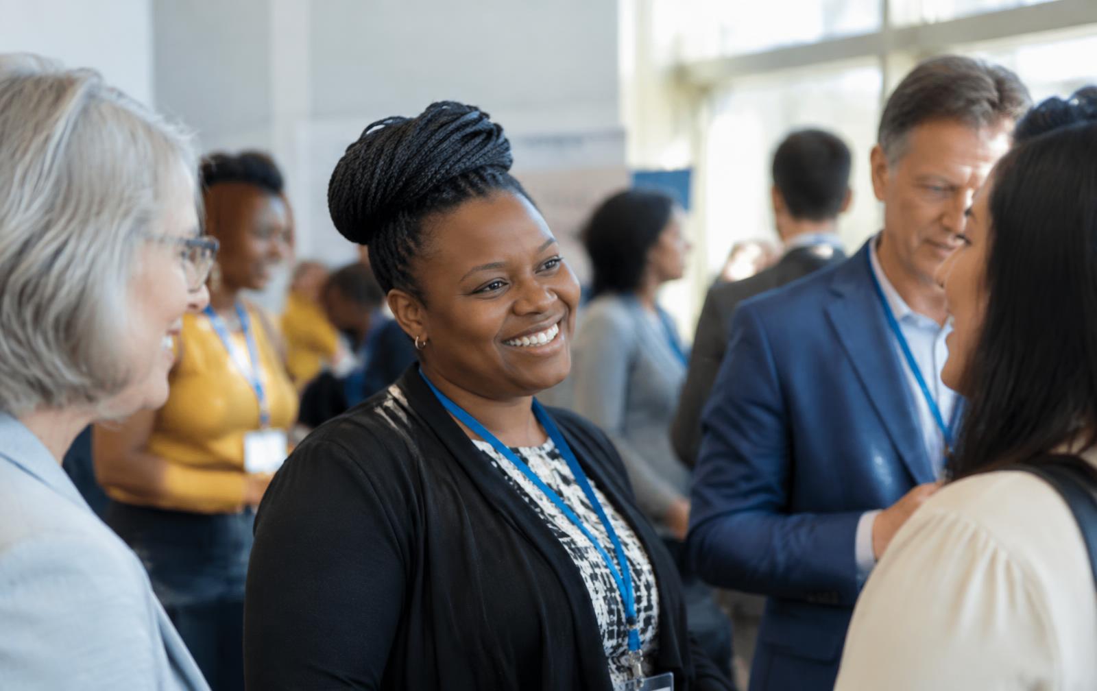 Social workers smiling and talking at a conference